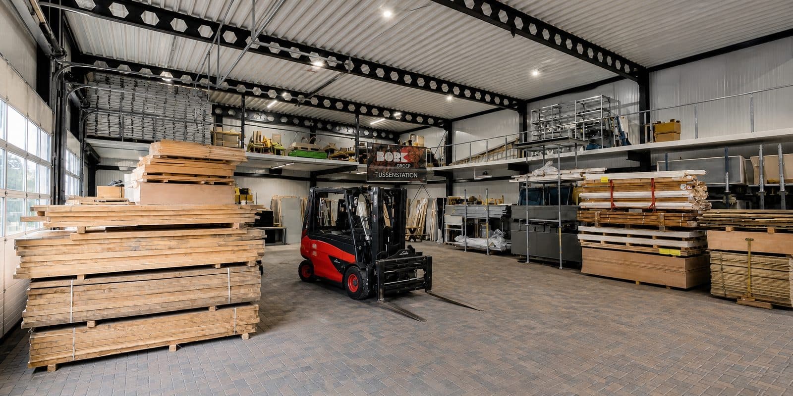 De hal van Tussenstation met stapels hout en de heftruck